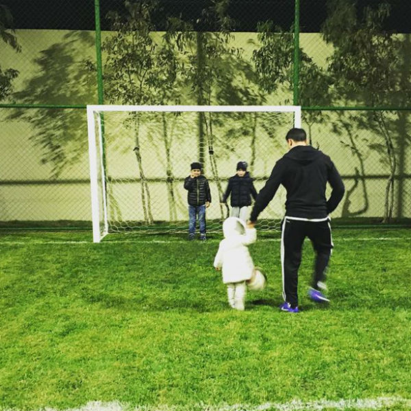 Старшие братья учат девочку играть в футбол
