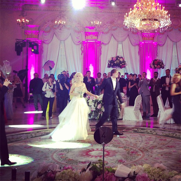 Молодожены проходят по залу к своим местам