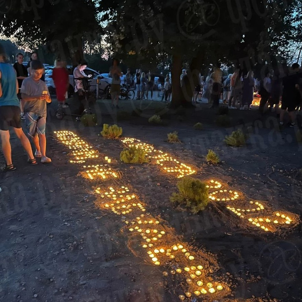 Люди свечами выложили послание миру